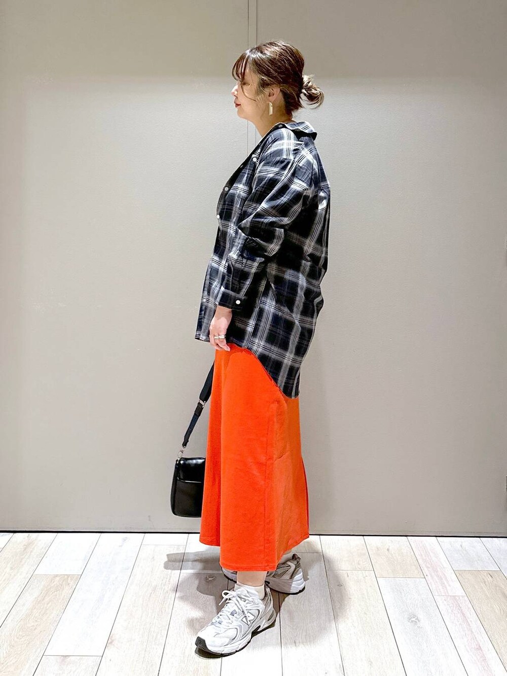 ブラック系のショルダーバッグ、ブラック系のシャツ/ブラウス、レッド系のスカートを着用したレディースの春コーディネートの4枚目の写真