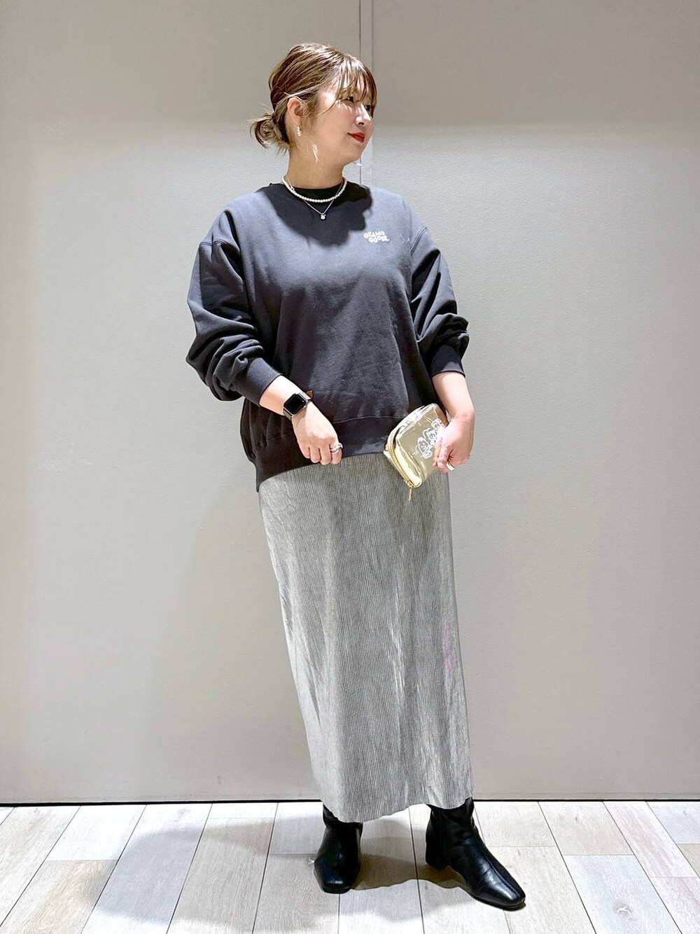 ブラック系のブーツ、シルバー系のスカート、グレー系のスウェットを着用したレディースの秋コーディネートの3枚目の写真