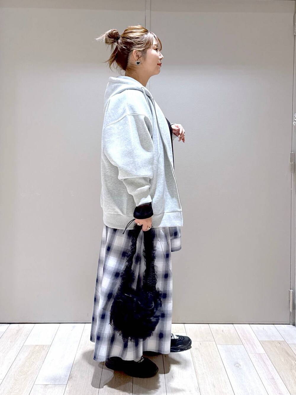 ブラック系のTシャツ/カットソー、オレンジ系のTシャツ/カットソー、グレー系のパーカーを着用したレディースの冬コーディネートの2枚目の写真