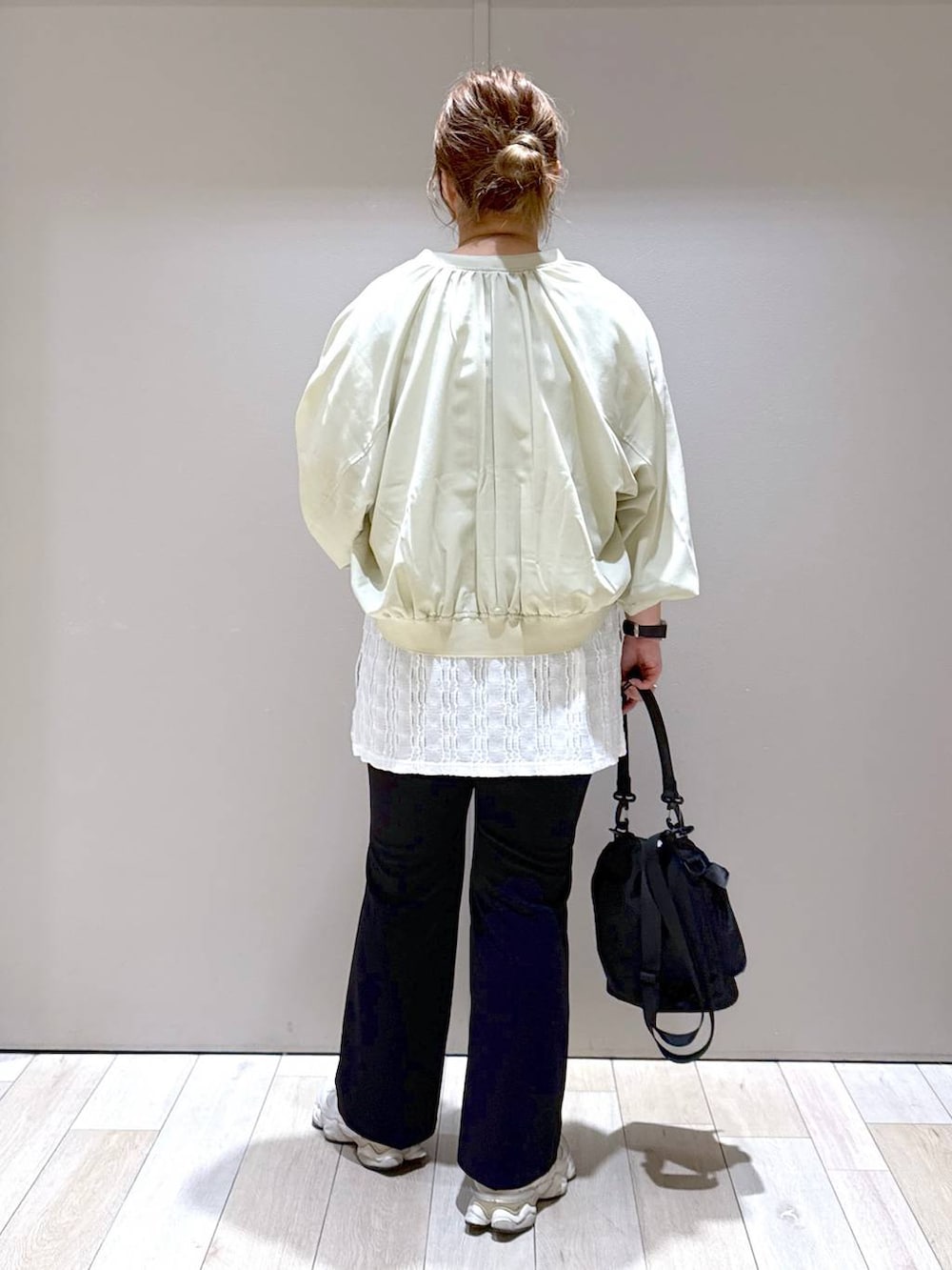 ブラック系のショルダーバッグ、ブラック系のスラックス、グリーン系のブルゾンを着用したレディースの春コーディネートの3枚目の写真