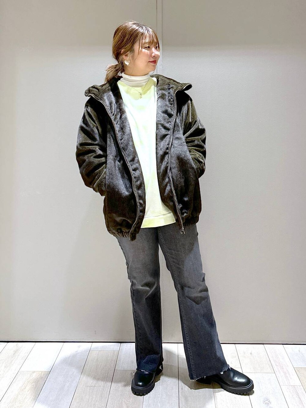 ホワイト系のTシャツ/カットソー、グリーン系のブルゾン、ブラック系のブーツを着用したレディースの冬コーディネートの5枚目の写真