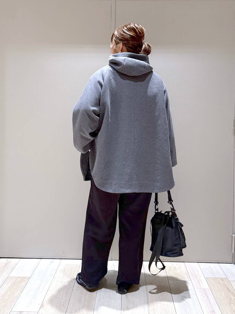 ブラック系のショルダーバッグ、グレー系のポンチョ、ブラック系のその他パンツを着用したレディースの冬コーディネートの3枚目の写真