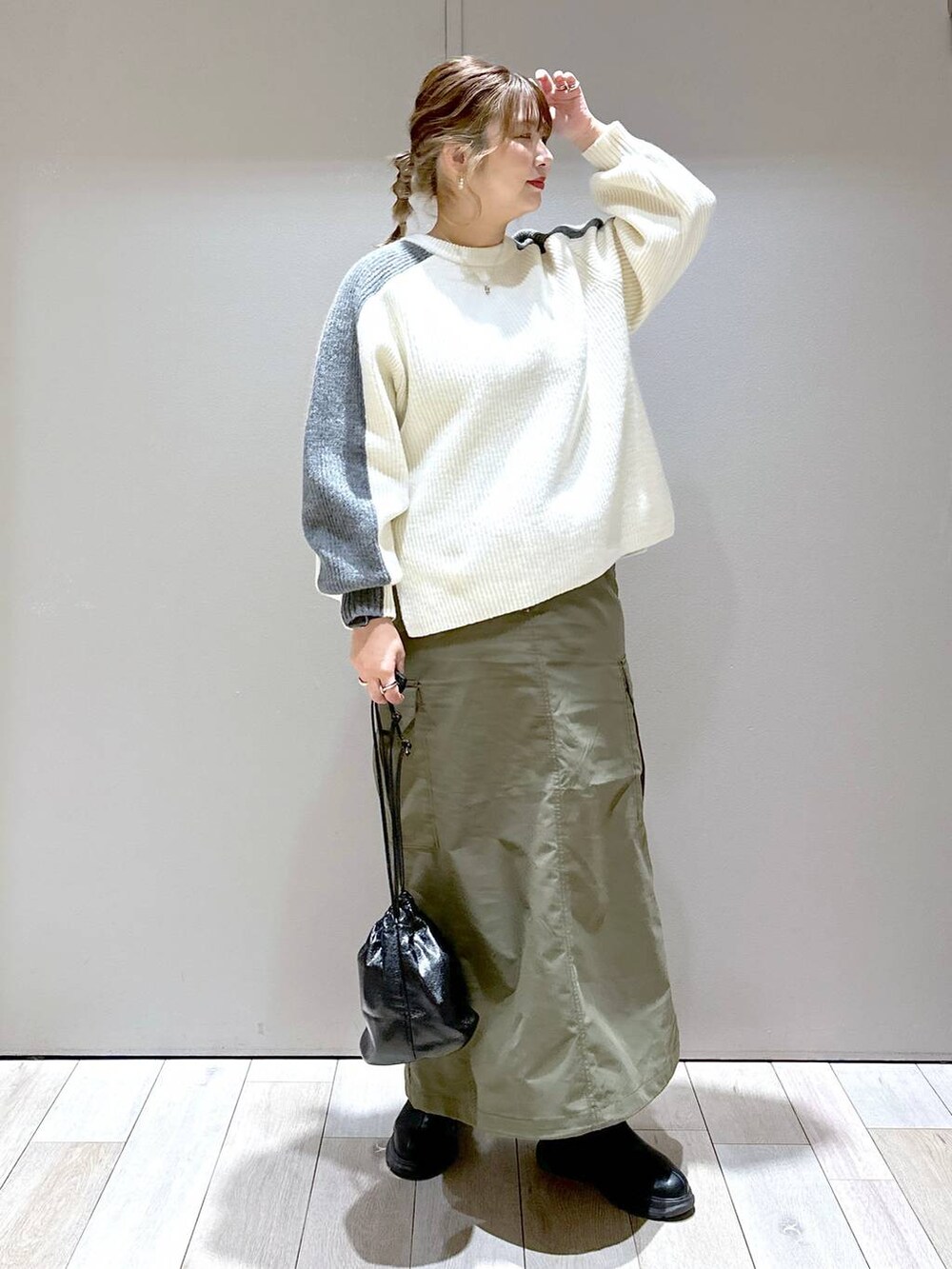 ホワイト系のニット/セーター、グリーン系のスカート、ブラック系のブーツを着用したレディースの冬コーディネートの6枚目の写真