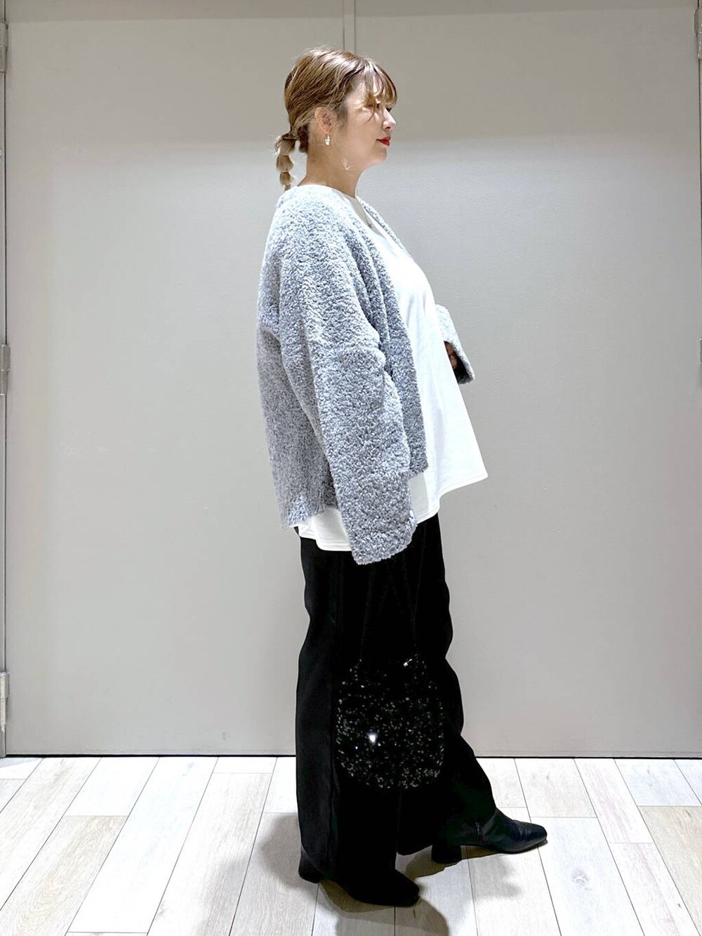 ブラック系のブーツ、ブラック系のその他パンツ、ゴールド系のピアス（両耳用）を着用したレディースの秋コーディネートの2枚目の写真