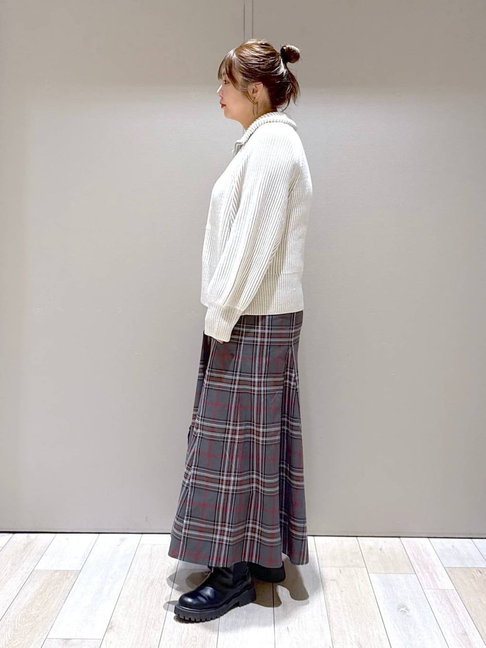 ブラック系のショルダーバッグ、ホワイト系のカーディガン/ボレロ、ブラック系のブーツを着用したレディースの冬コーディネートの4枚目の写真