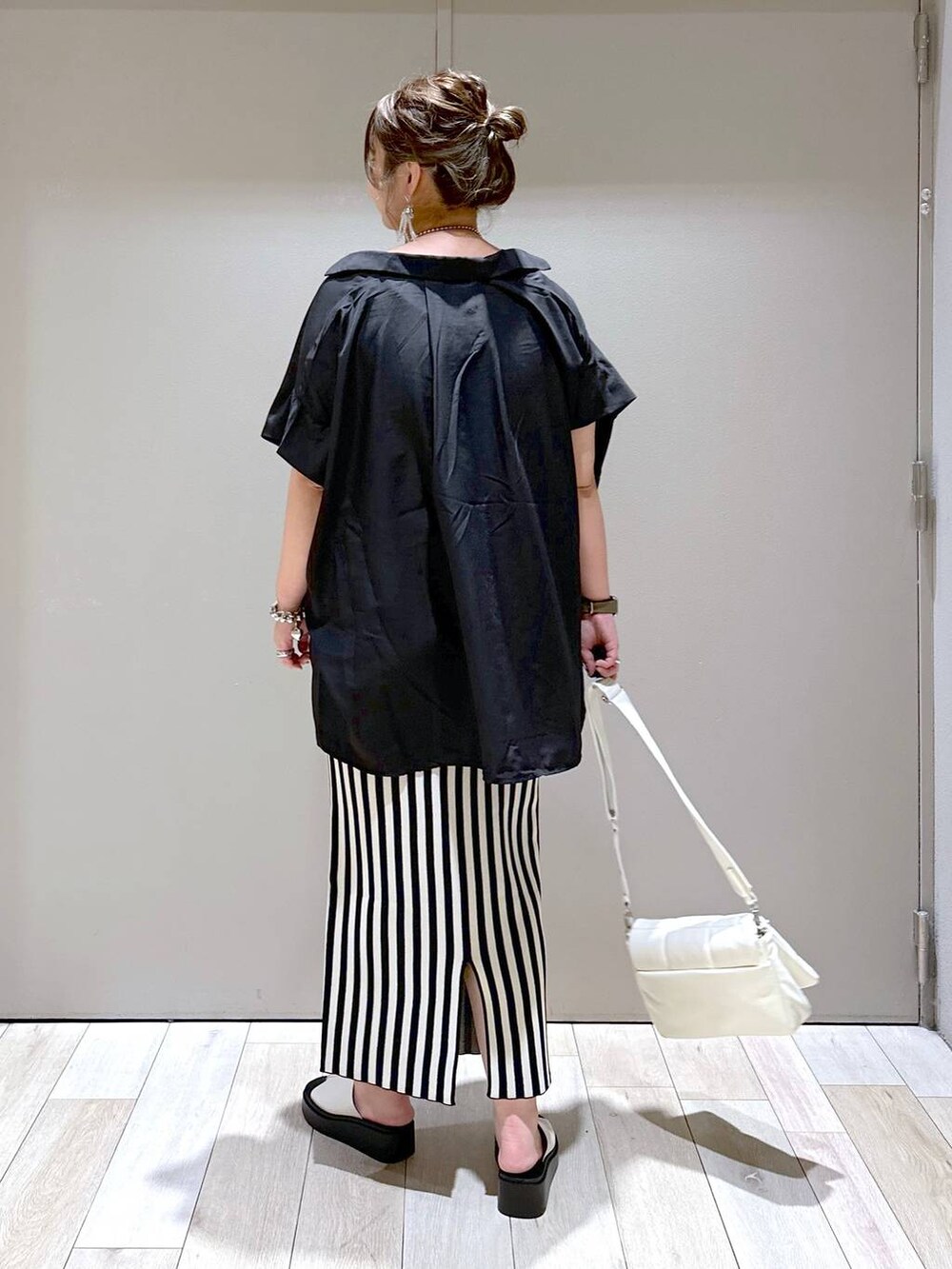 ホワイト系のショルダーバッグ、ブラック系のシャツ/ブラウス、ホワイト系のスカートを着用したレディースの春コーディネートの3枚目の写真