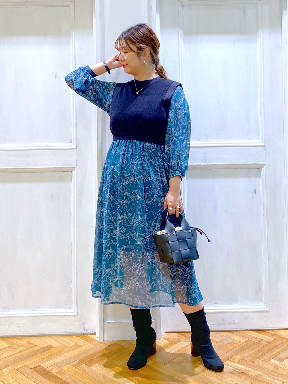 グリーン系のワンピース、グリーン系のショルダーバッグ、ブラック系のブーツを着用したレディースの秋コーディネートの2枚目の写真