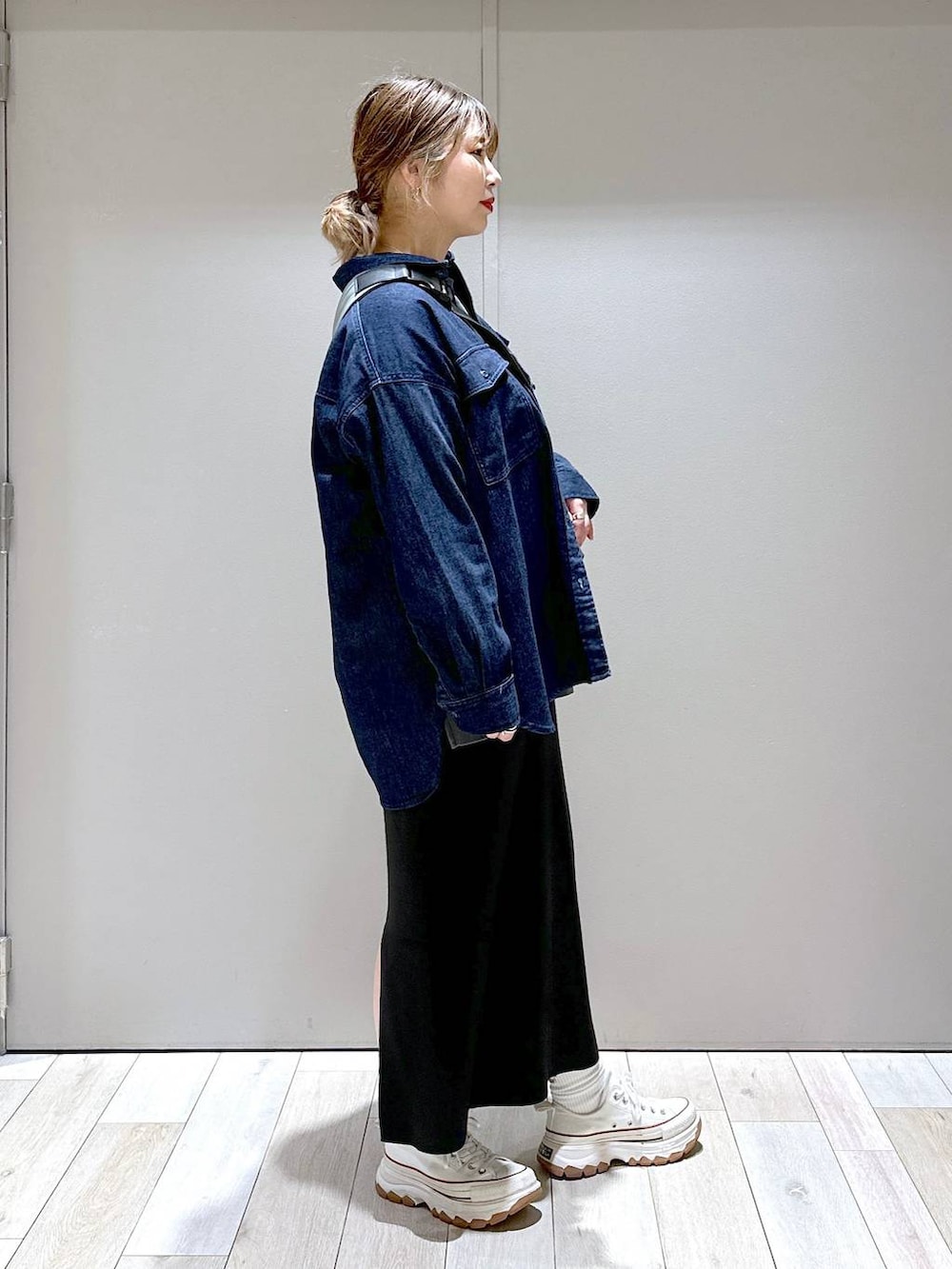 ブラック系のスカート、ベージュ系のボディバッグ/ウエストポーチ、グレー系のTシャツ/カットソーを着用したレディースの秋コーディネートの2枚目の写真