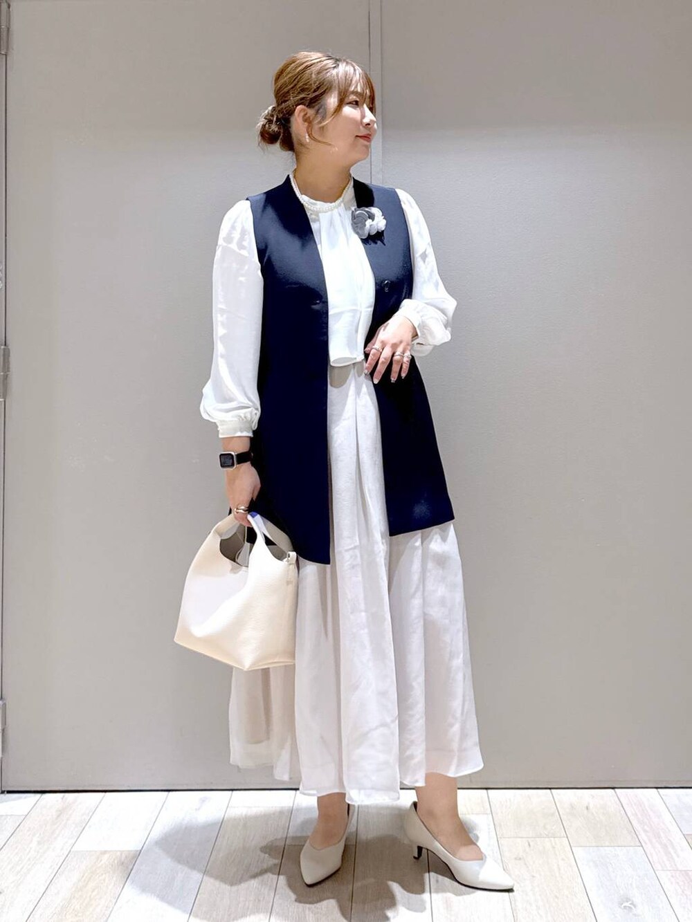 ベージュ系のスカート、ホワイト系のシャツ/ブラウス、ブルー系のスーツベストを着用したレディースの冬コーディネートの4枚目の写真