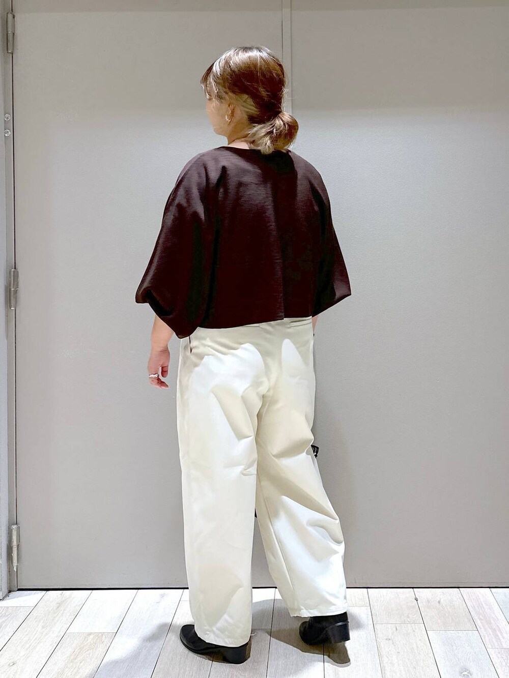 ブラウン系のニット/セーター、ブラック系のブーツ、ホワイト系のその他パンツを着用したレディースの秋コーディネートの2枚目の写真