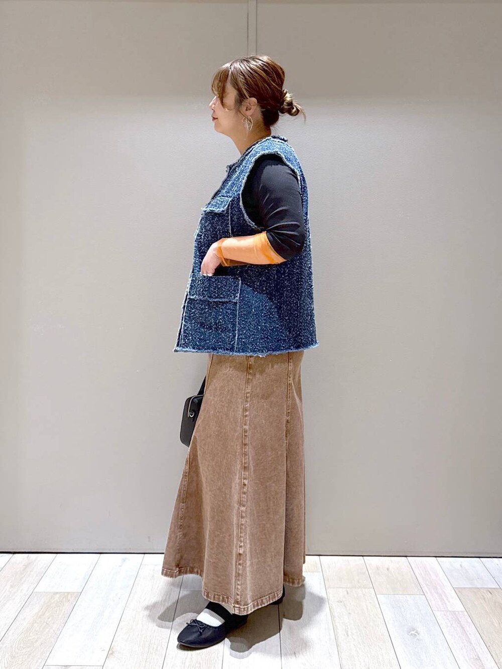 ブラック系のTシャツ/カットソー、ブラック系のパンプス、ブラック系のボストンバッグを着用したレディースの冬コーディネートの4枚目の写真