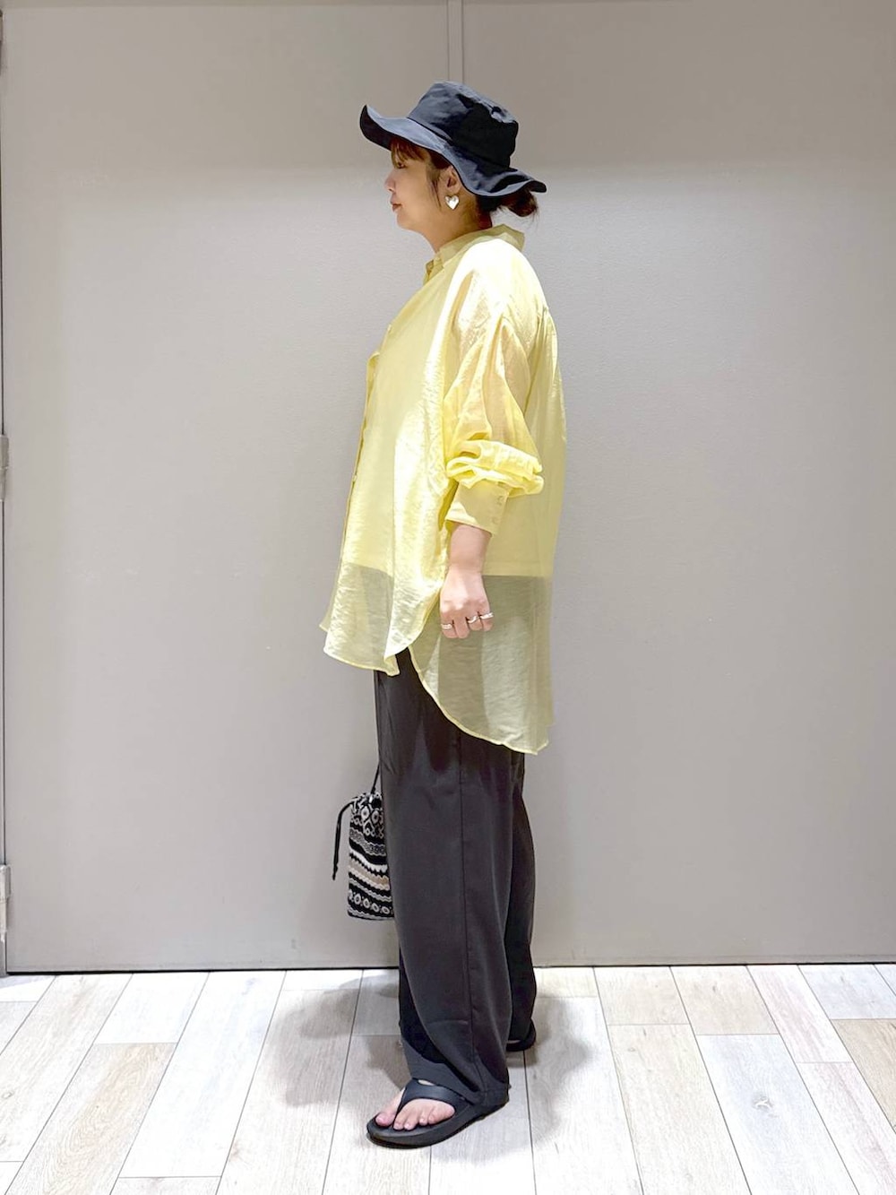 グレー系のその他パンツ、イエロー系のシャツ/ブラウス、ブラック系のサンダルを着用したレディースの秋コーディネートの4枚目の写真