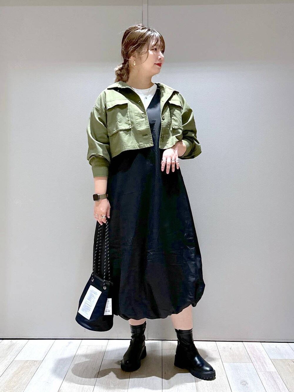 ホワイト系のTシャツ/カットソー、グリーン系のミリタリージャケット、ブラック系のブーツを着用したレディースの秋コーディネートの4枚目の写真