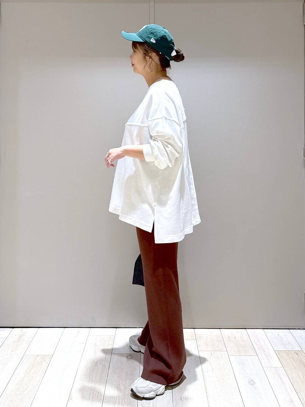 ブラック系のショルダーバッグ、ホワイト系のTシャツ/カットソー、ブラウン系のマタニティウェア/グッズを着用したレディースの秋コーディネートの4枚目の写真