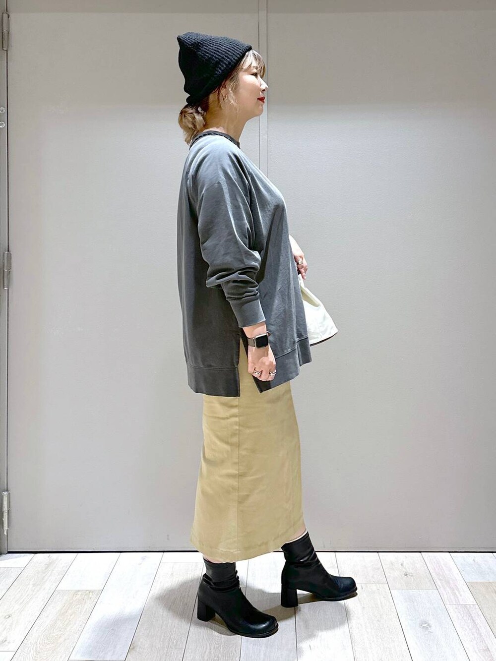 グレー系のTシャツ/カットソー、ブラック系のブーツ、ブラック系のニットキャップ/ビーニーを着用したレディースの秋コーディネートの2枚目の写真