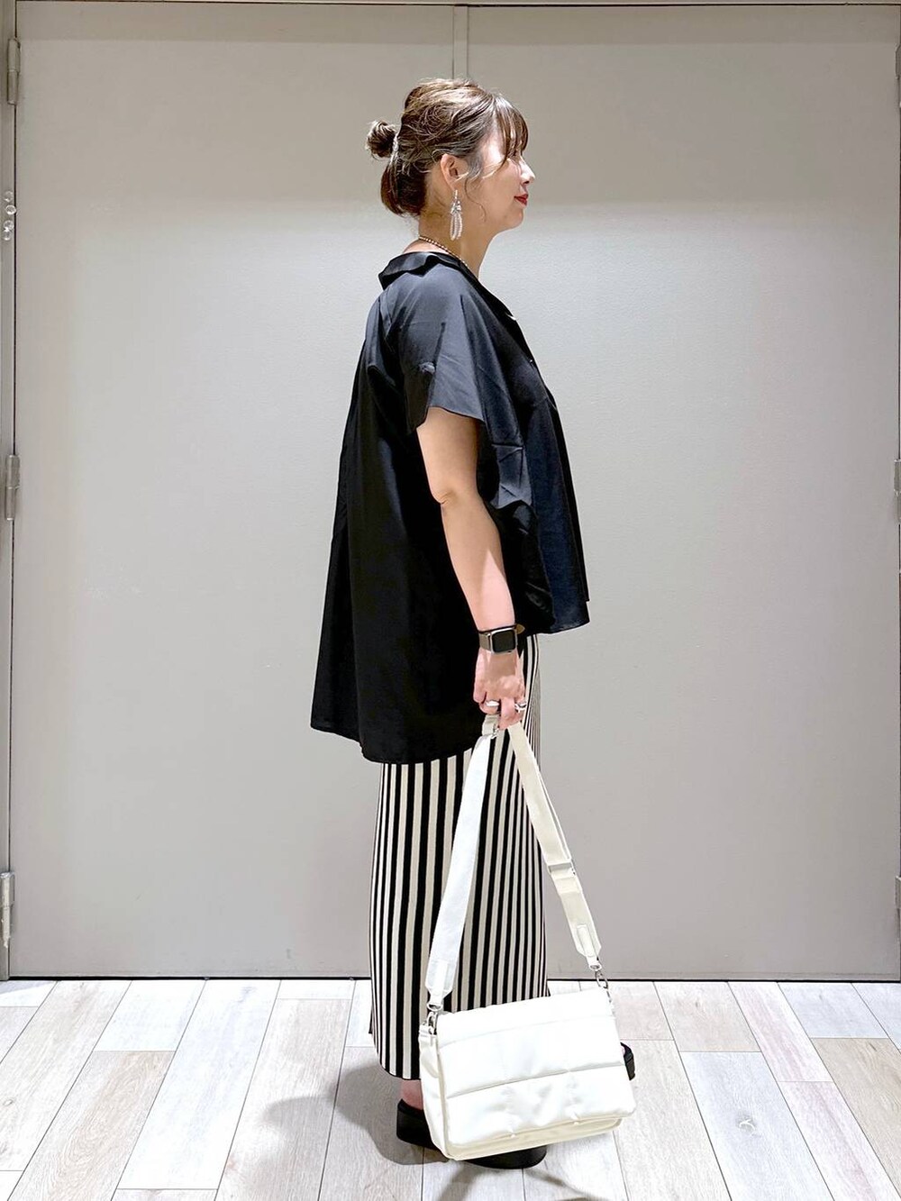 ホワイト系のショルダーバッグ、ブラック系のシャツ/ブラウス、ホワイト系のスカートを着用したレディースの春コーディネートの2枚目の写真