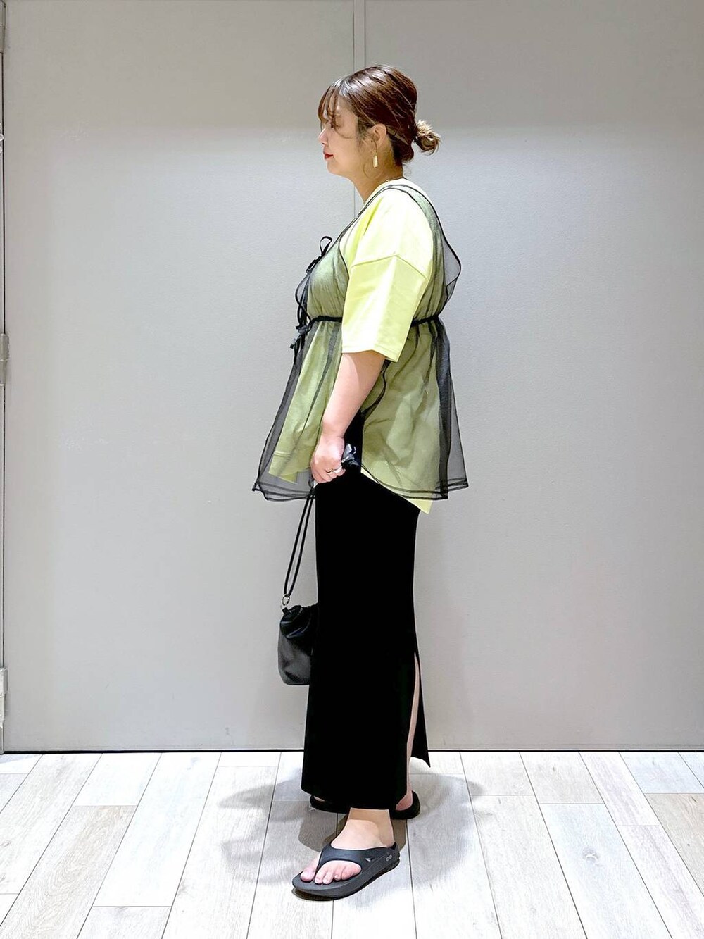 ブラック系のショルダーバッグ、ブラック系のベスト、ブラック系のサンダルを着用したレディースの春コーディネートの4枚目の写真