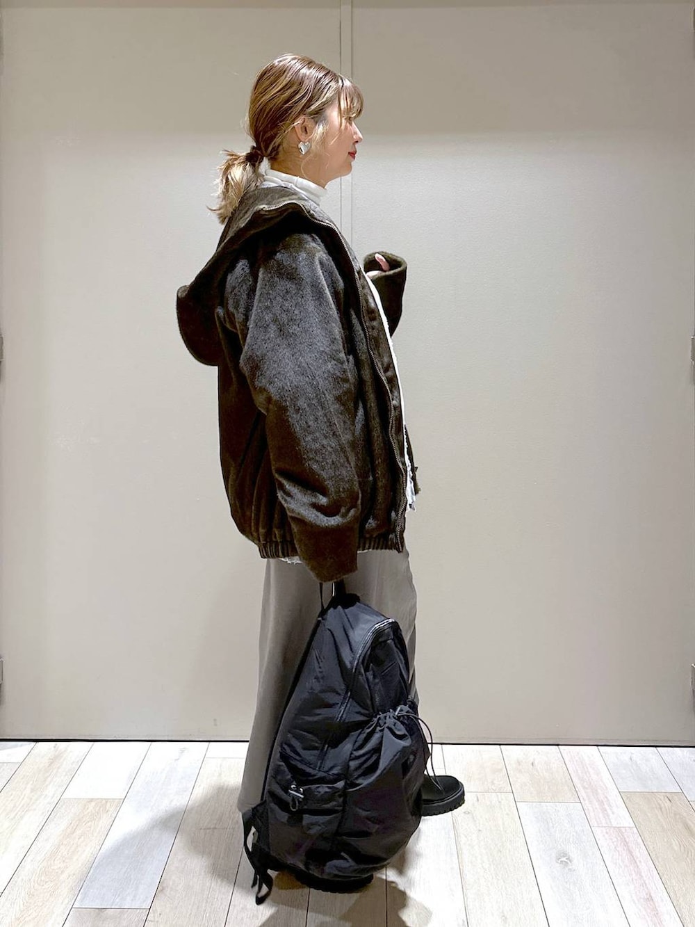 ホワイト系のTシャツ/カットソー、ブラック系のブーツ、グリーン系のブルゾンを着用したレディースの冬コーディネートの3枚目の写真