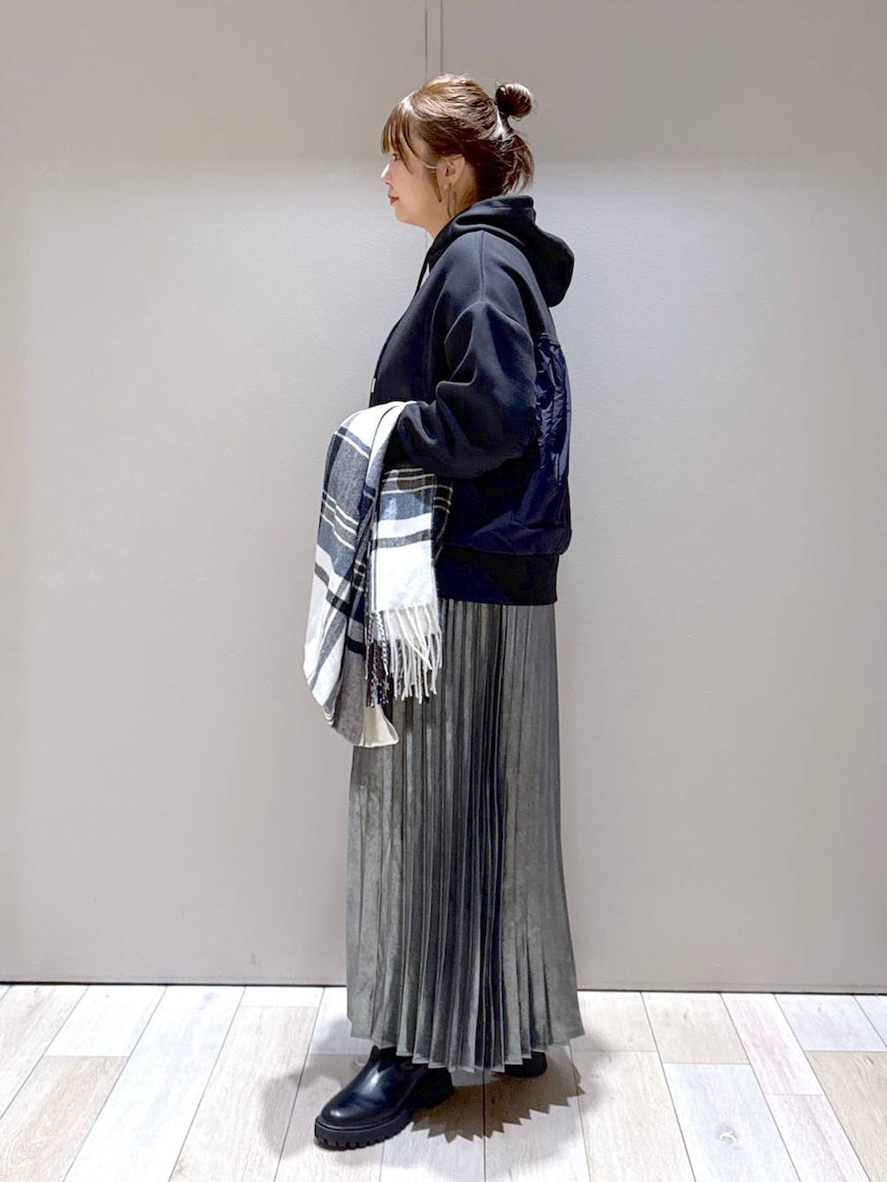 ブラック系のブーツ、ブラック系のパーカー、グレー系のスカートを着用したレディースの冬コーディネートの4枚目の写真