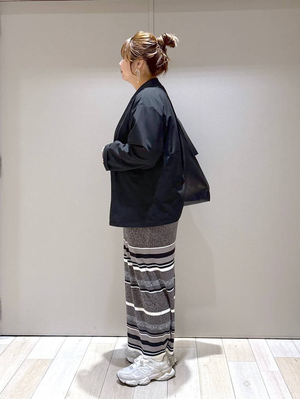 ブラック系のテーラードジャケット、ブラック系のスカート、ブラック系のトートバッグを着用したレディースの春コーディネートの4枚目の写真