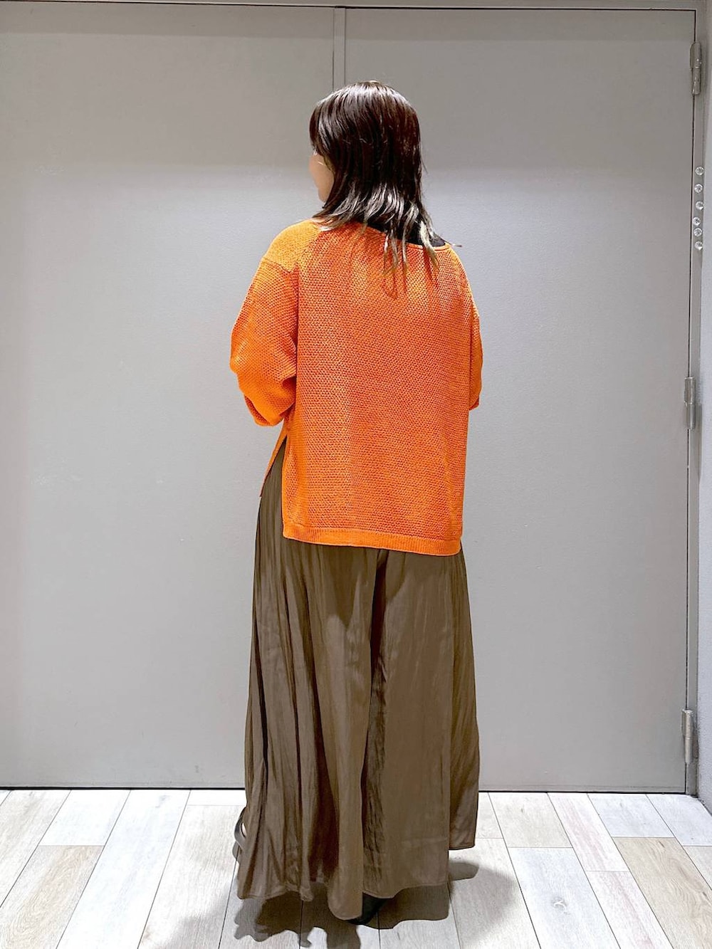 ブラック系のショルダーバッグ、オレンジ系のニット/セーター、ブラウン系のその他パンツを着用したレディースの秋コーディネートの3枚目の写真