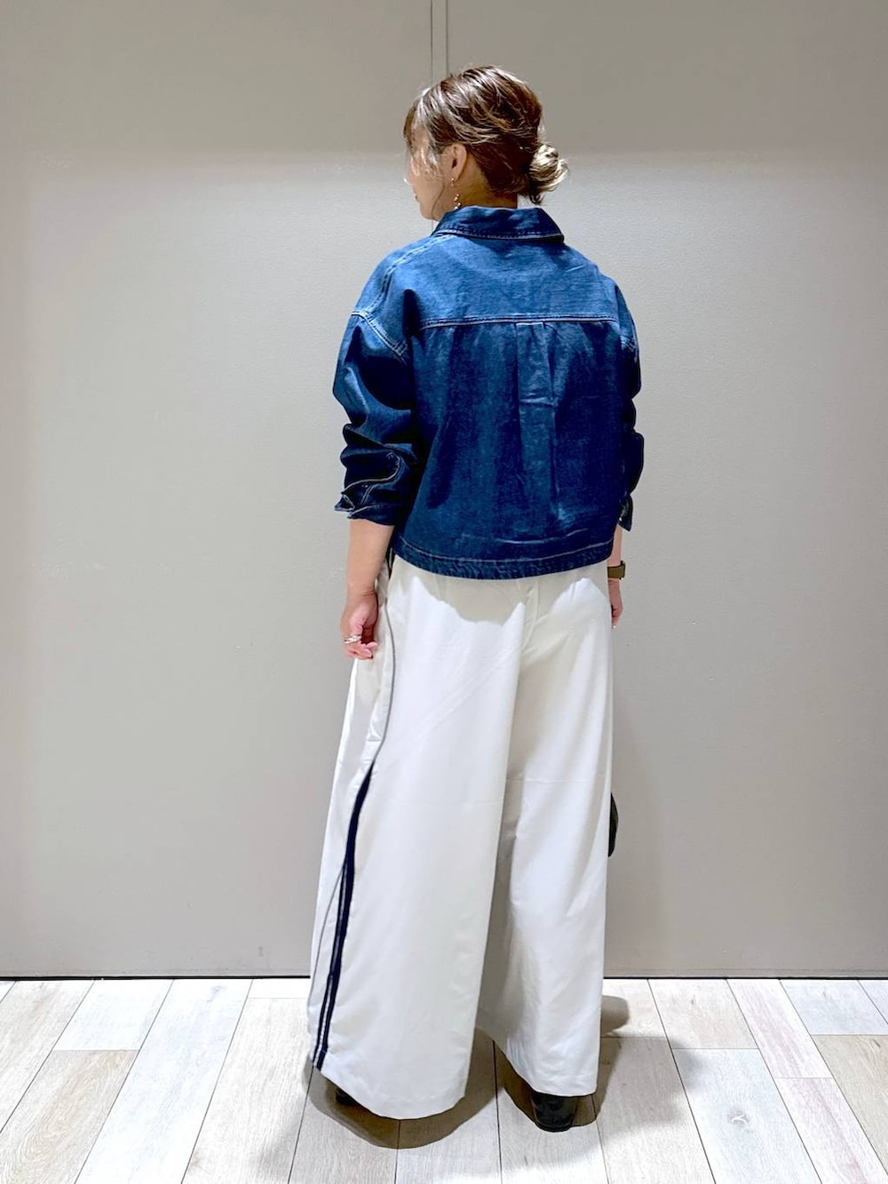 ブラック系のショルダーバッグ、ブラック系のパンプス、ブルー系のシャツ/ブラウスを着用したレディースの春コーディネートの3枚目の写真