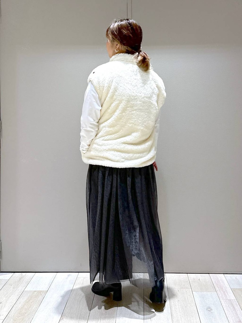 ホワイト系のその他アウター、ブラック系のブーツ、ホワイト系のTシャツ/カットソーを着用したレディースの秋コーディネートの3枚目の写真