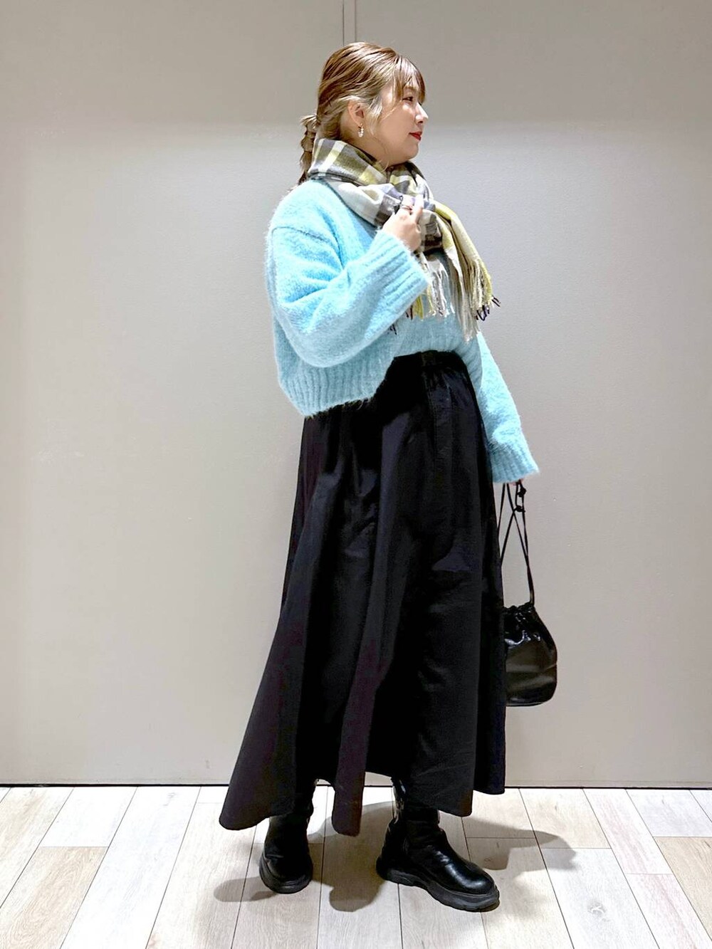 ブラック系のショルダーバッグ、ブラック系のブーツ、ブラック系のスカートを着用したレディースの冬コーディネートの2枚目の写真