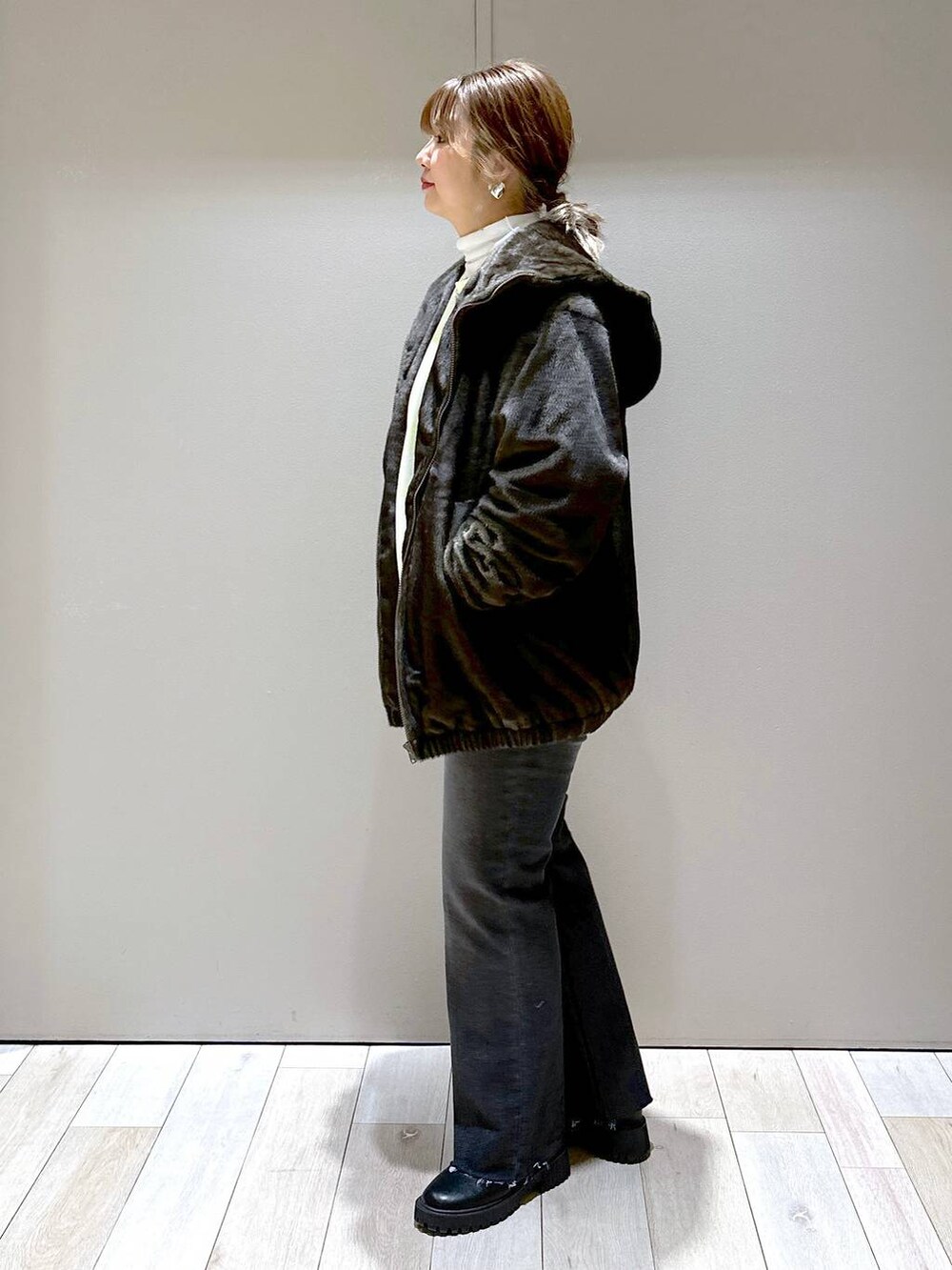 ホワイト系のTシャツ/カットソー、グリーン系のブルゾン、ブラック系のブーツを着用したレディースの冬コーディネートの4枚目の写真