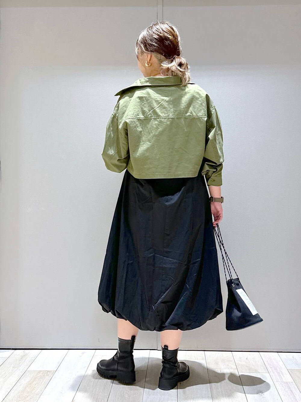 ホワイト系のTシャツ/カットソー、グリーン系のミリタリージャケット、ブラック系のブーツを着用したレディースの秋コーディネートの3枚目の写真