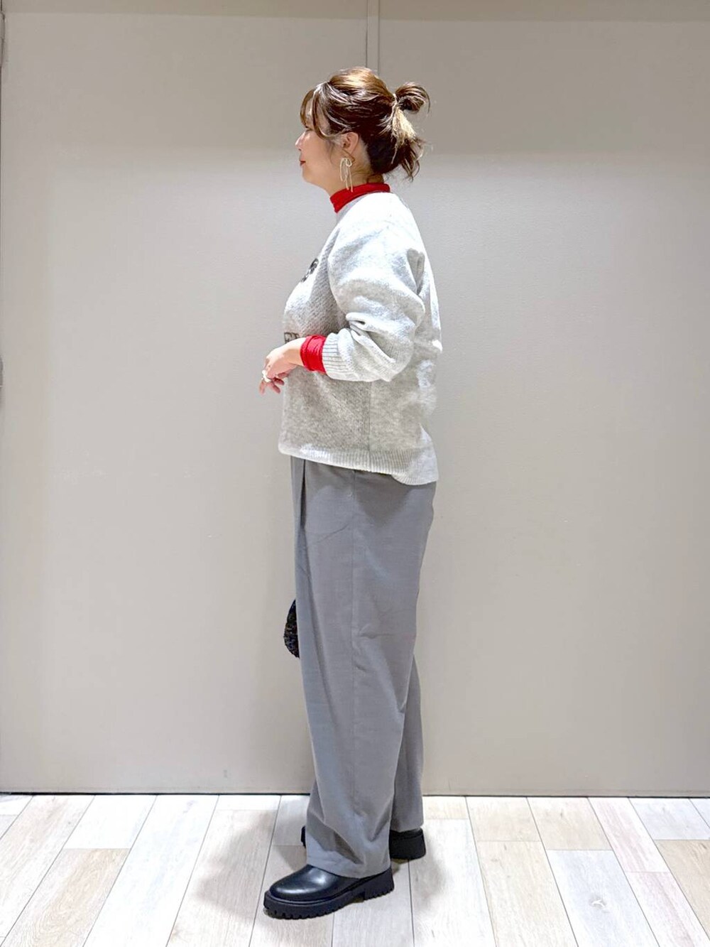 ブラック系のブーツ、ブラック系のショルダーバッグ、レッド系のTシャツ/カットソーを着用したレディースの冬コーディネートの4枚目の写真