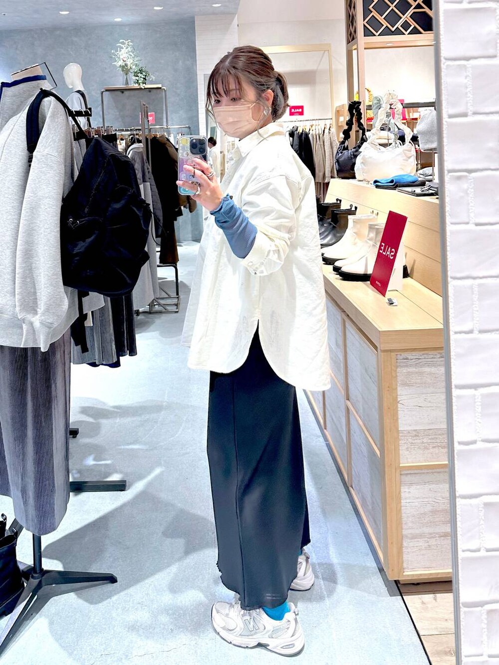 ブラック系のスカート、ホワイト系のシャツ/ブラウス、ブルー系のTシャツ/カットソーを着用したレディースの冬コーディネートの2枚目の写真