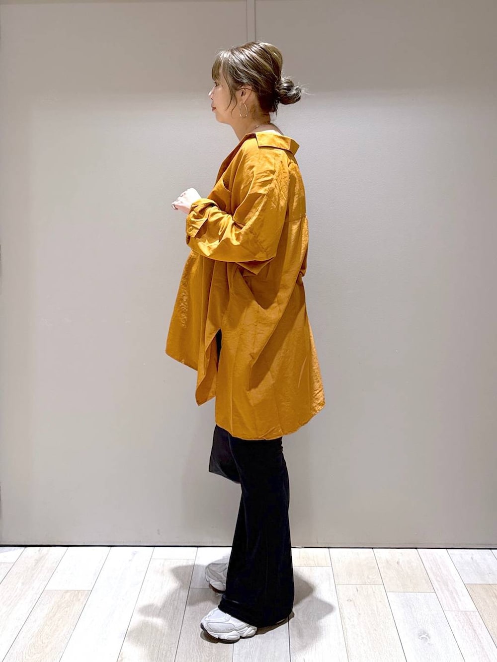 オレンジ系のシャツ/ブラウス、ブラック系のショルダーバッグ、ブラック系のその他パンツを着用したレディースの秋コーディネートの4枚目の写真