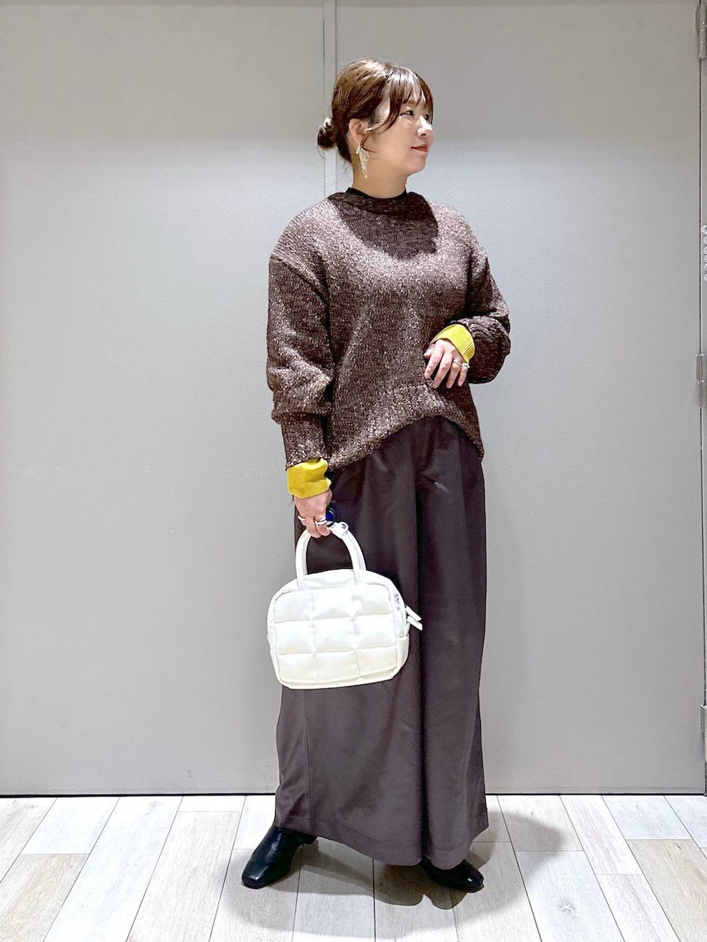 ブラック系のニット/セーター、グレー系のその他パンツ、ホワイト系のボストンバッグを着用したレディースの秋コーディネートの5枚目の写真