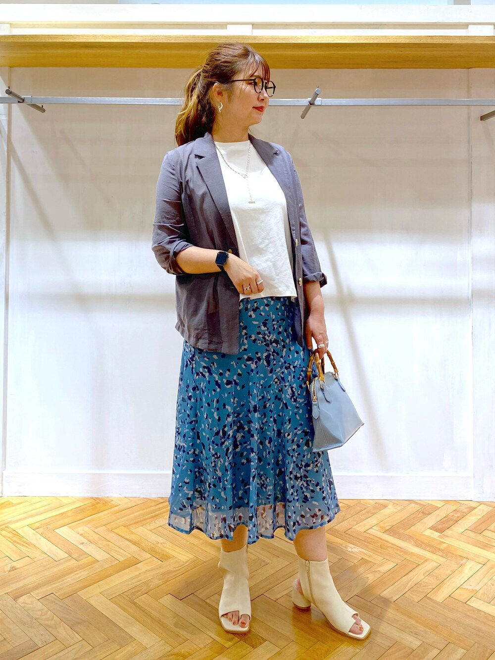 ホワイト系のTシャツ/カットソー、グレー系のテーラードジャケット、ブルー系のスカートを着用したレディースの夏コーディネートの4枚目の写真