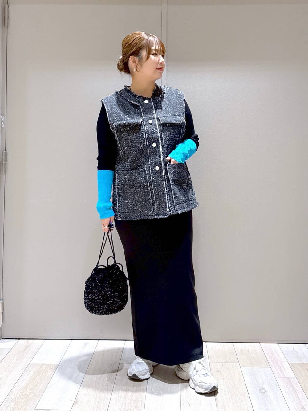 ブラック系のショルダーバッグ、ブラック系のスカート、ブラック系のニット/セーターを着用したレディースの冬コーディネートの5枚目の写真