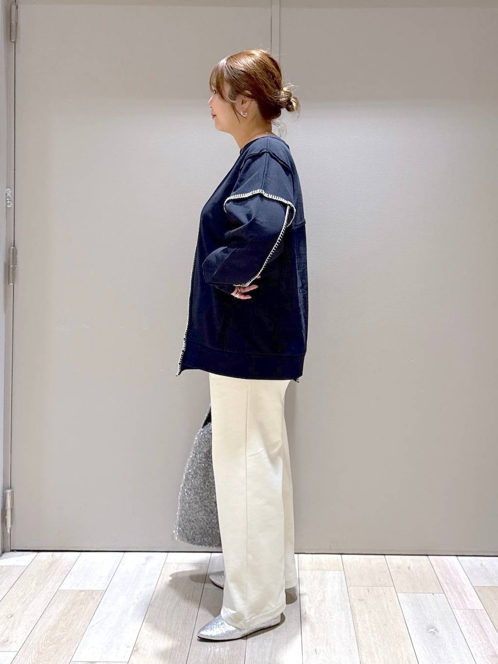 シルバー系のショルダーバッグ、グレー系のパンプス、ブラック系のワンピースを着用したレディースの冬コーディネートの4枚目の写真