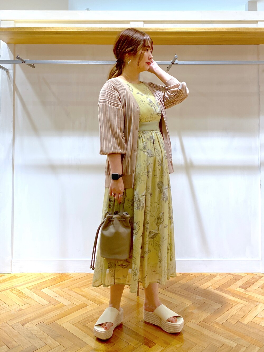 イエロー系のワンピース、ブラウン系のカーディガン/ボレロ、グレー系のショルダーバッグを着用したレディースの夏コーディネートの2枚目の写真