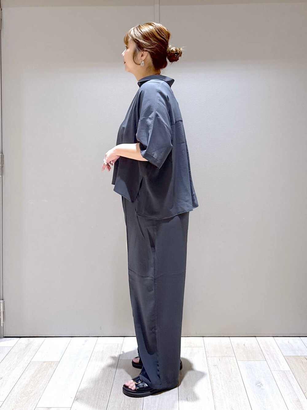 グレー系のその他パンツ、ブラック系のサンダル、ホワイト系のショルダーバッグを着用したレディースの夏コーディネートの4枚目の写真