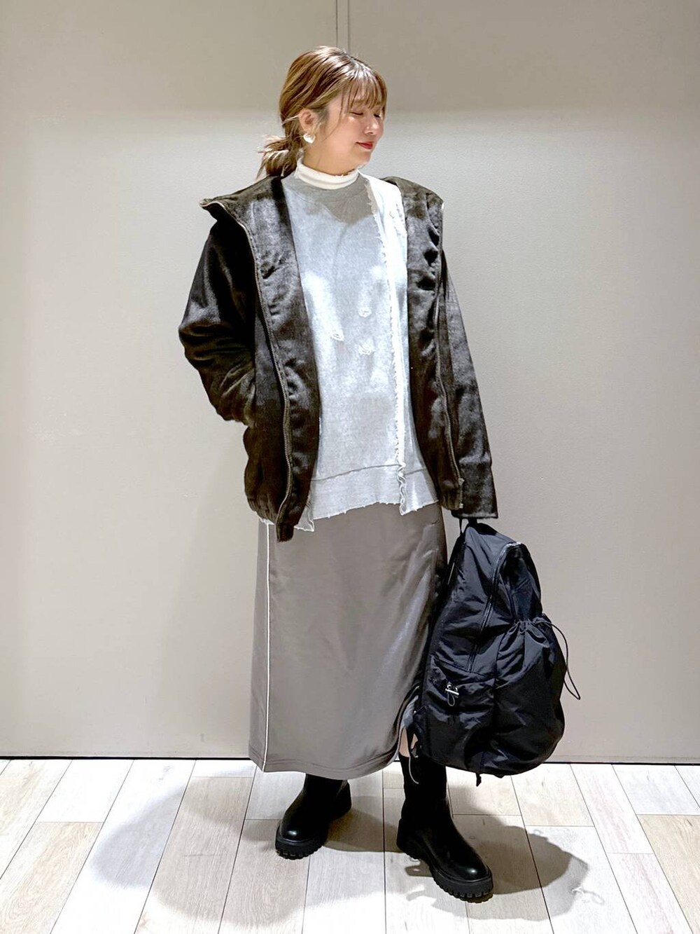 ホワイト系のTシャツ/カットソー、ブラック系のブーツ、グリーン系のブルゾンを着用したレディースの冬コーディネートの2枚目の写真