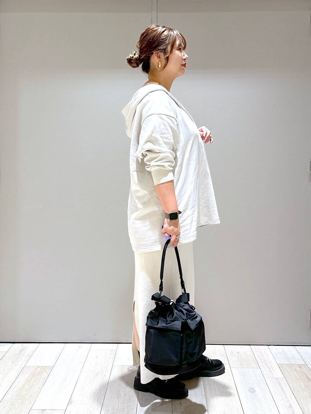 ブラック系のショルダーバッグ、ブラック系のローファー、ホワイト系のスカートを着用したレディースの秋コーディネートの2枚目の写真