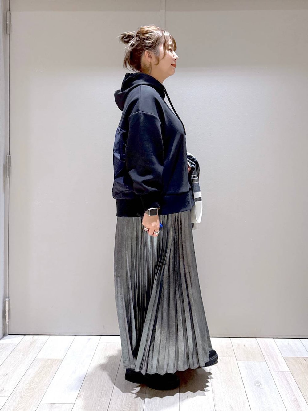 ブラック系のブーツ、ブラック系のパーカー、グレー系のスカートを着用したレディースの冬コーディネートの3枚目の写真