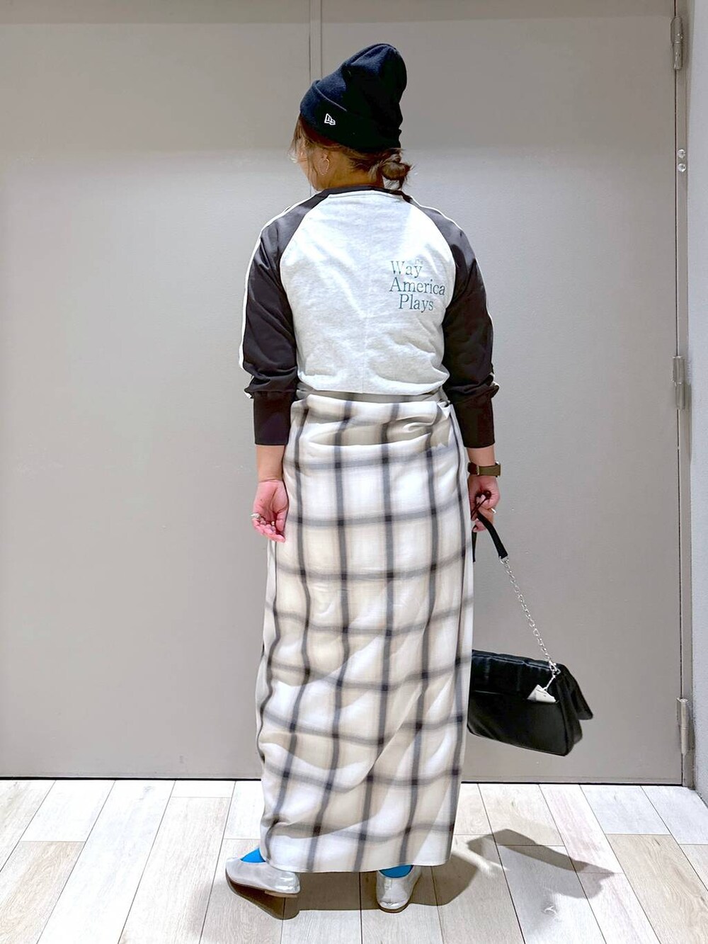 ブラック系のショルダーバッグ、グレー系のパンプス、ブラック系のワンピースを着用したレディースの春コーディネートの2枚目の写真