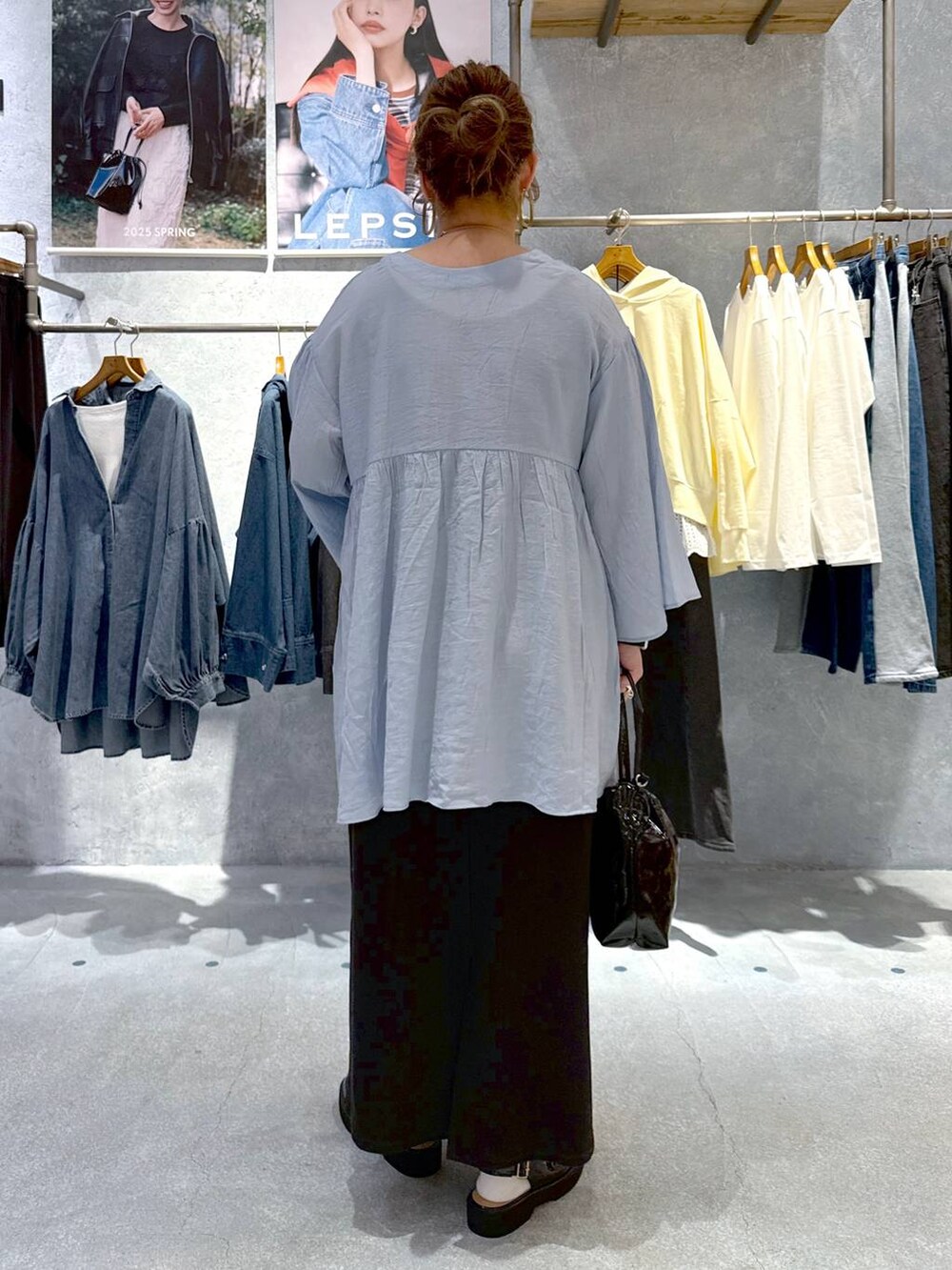 ブラック系のローファー、ブラック系のショルダーバッグ、ブラック系のスカートを着用したレディースの春コーディネートの3枚目の写真