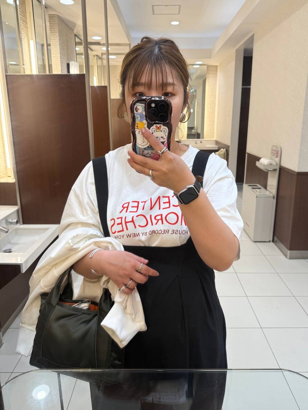 ブラック系のサロペット/オーバーオール、ホワイト系のTシャツ/カットソーを着用したレディースの春コーディネートの2枚目の写真