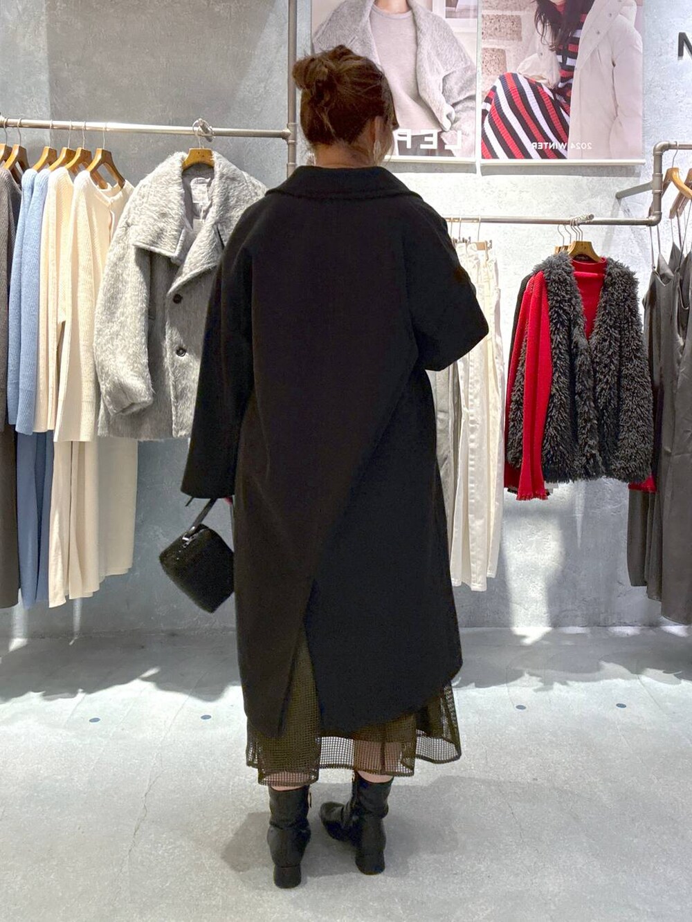 ブラック系のその他アウター、ブラック系のブーツ、グリーン系のドレスを着用したレディースの秋コーディネートの3枚目の写真