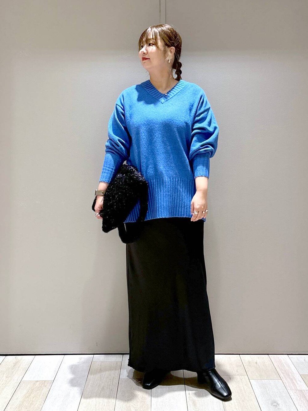 ブラック系のブーツ、ブラック系のショルダーバッグ、ブラック系のスカートを着用したレディースの秋コーディネートの4枚目の写真