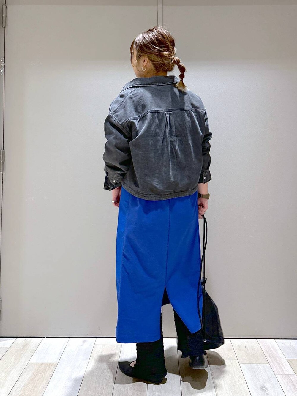 ブラック系のショルダーバッグ、ブルー系のワンピース、ブラック系のパンプスを着用したレディースの春コーディネートの3枚目の写真