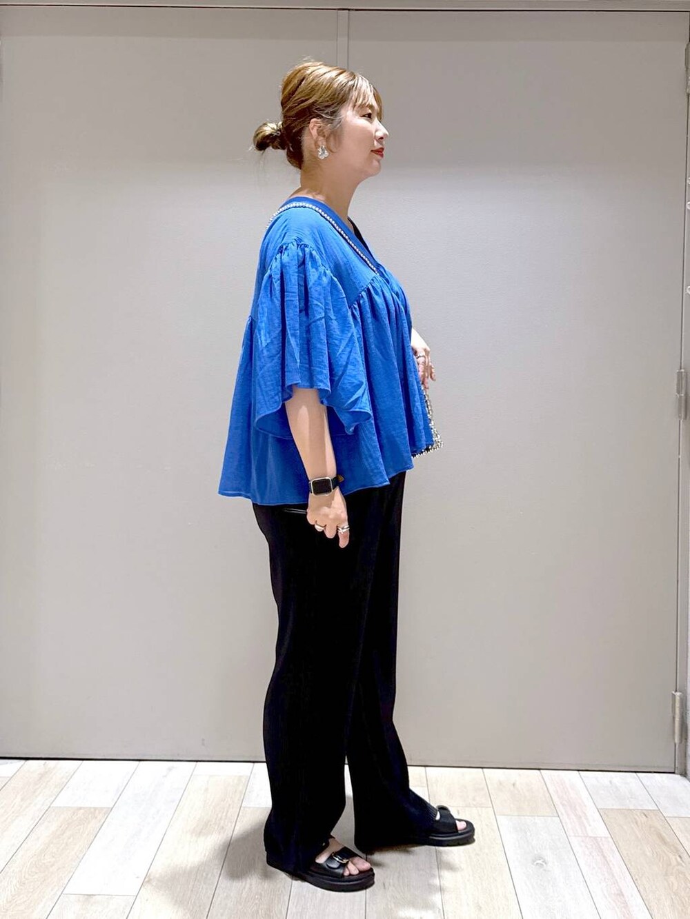 ブルー系のシャツ/ブラウス、ブラック系のTシャツ/カットソー、ブラック系のサンダルを着用したレディースの春コーディネートの2枚目の写真