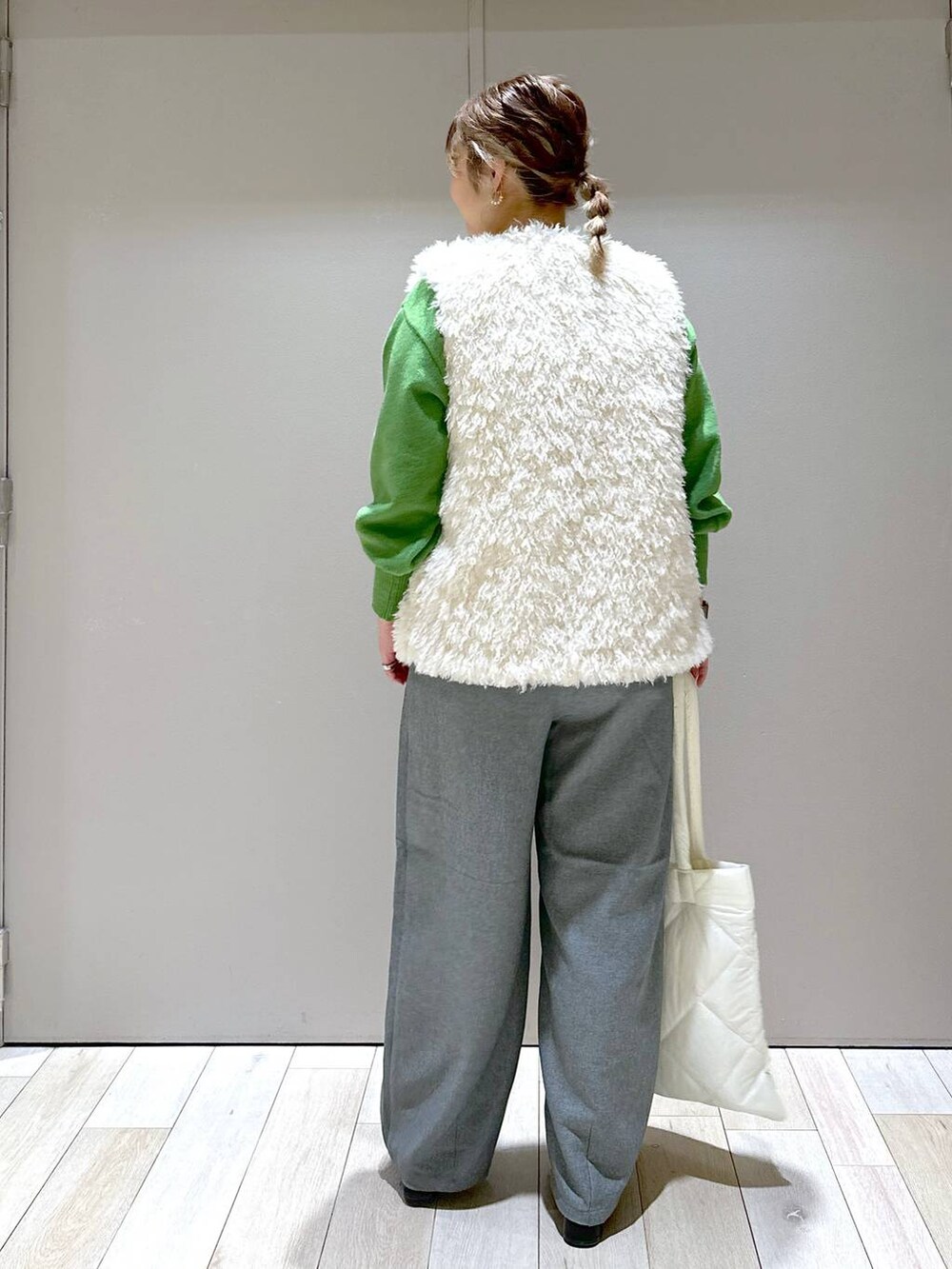 ブラック系のブーツ、ホワイト系のトートバッグ、グレー系のその他パンツを着用したレディースの秋コーディネートの3枚目の写真